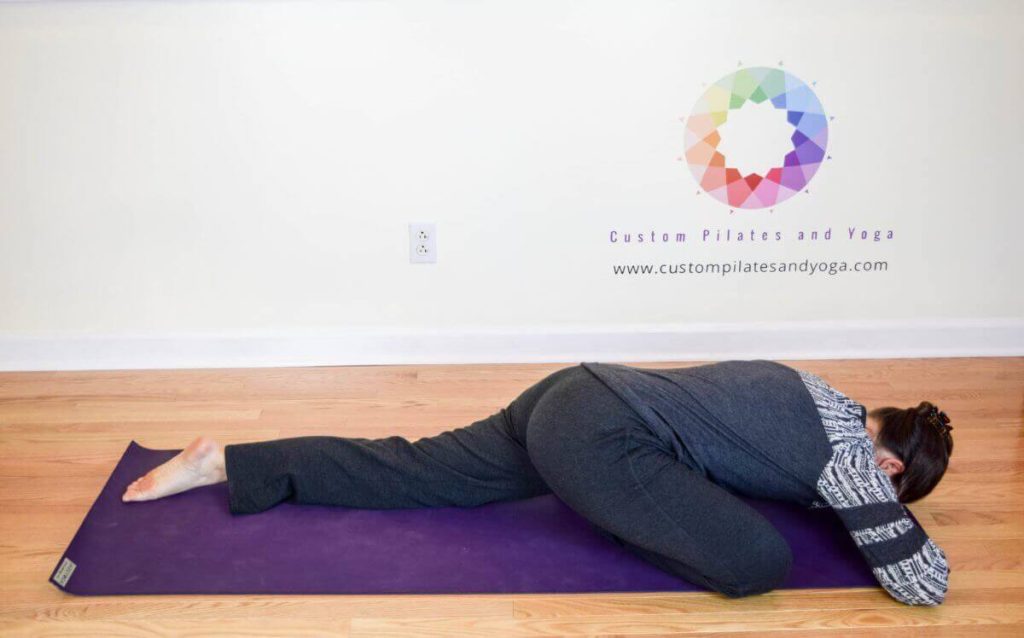 picture of Sarah Stockett doing the sleeping pigeon yoga pose